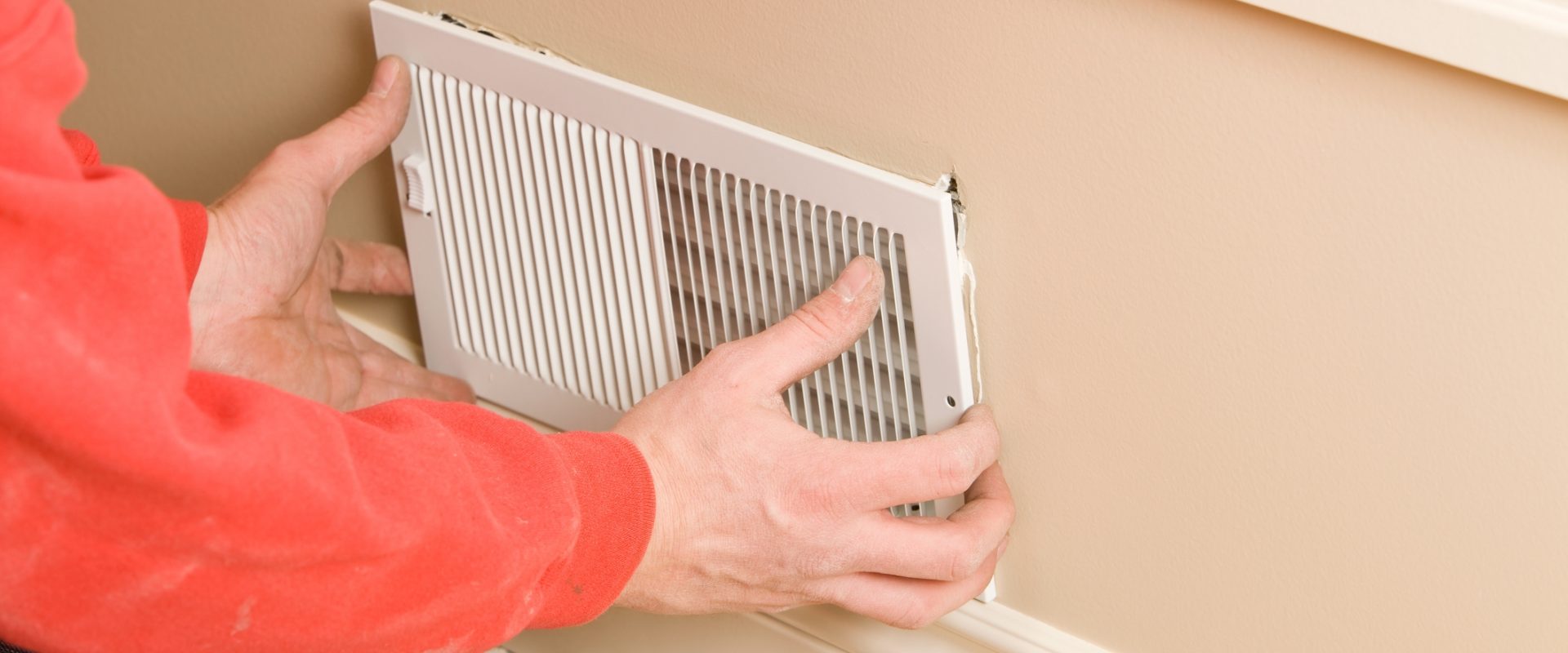 Person installing a residential HVAC vent.